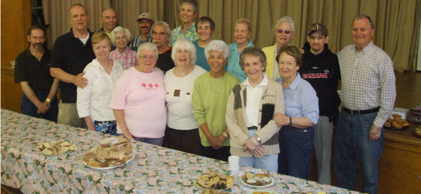 group of people in front of a table of food at the soup kitchen