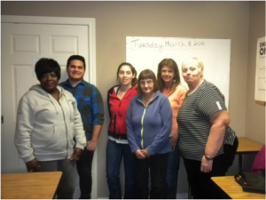 A group of people standing in an office 