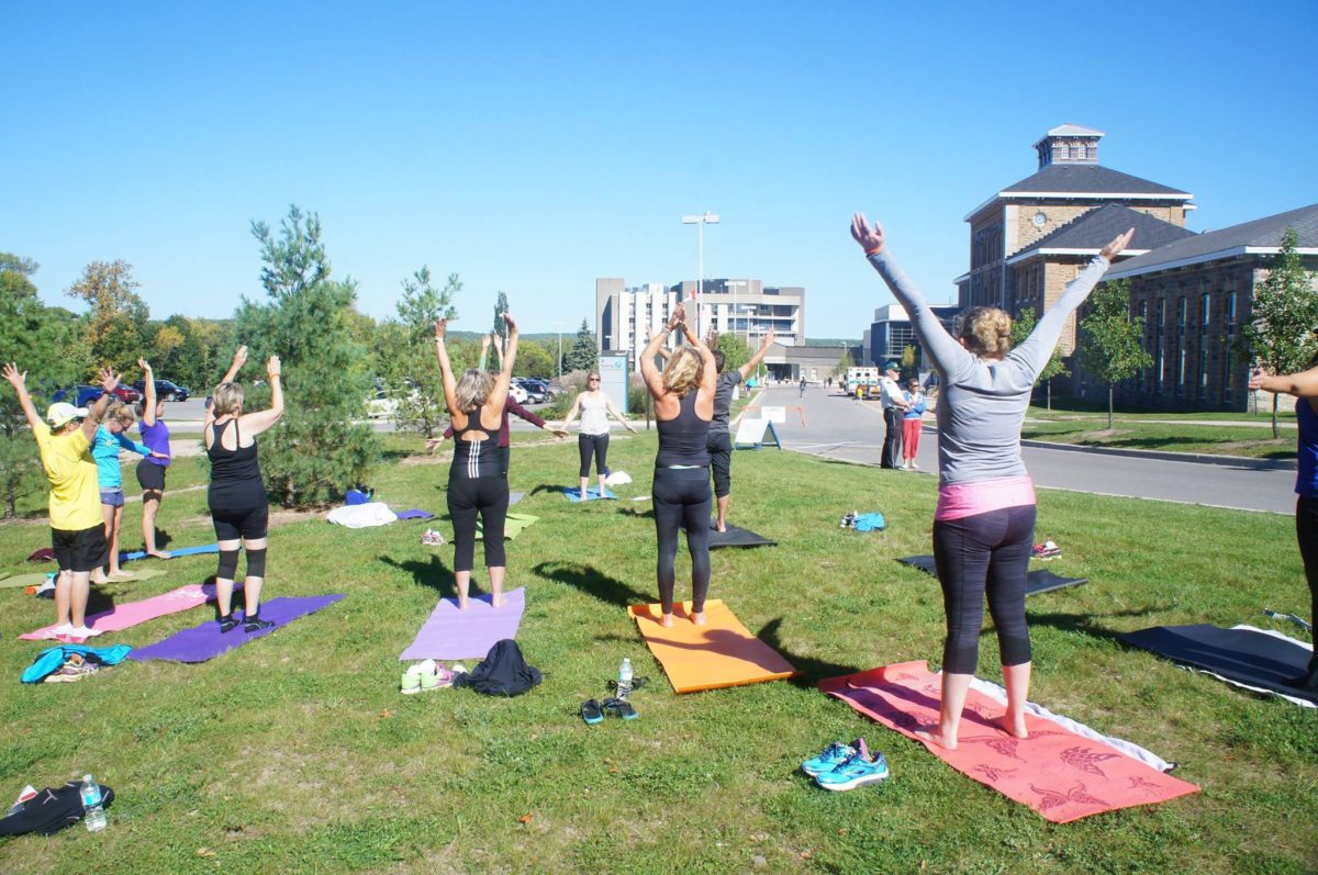 A group of women doing yoga outside